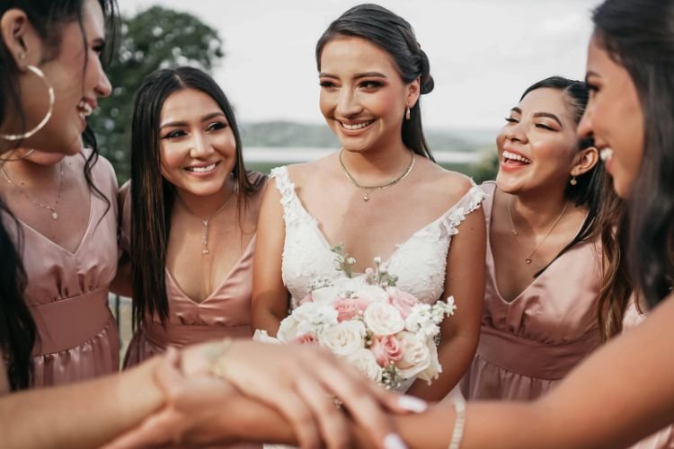 A calm bride is surrounded by the support of her bridesmaids on her wedding day.