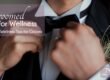A groom straightens his tie. Wedding wellness for grooms can help relieve stress before the big day.