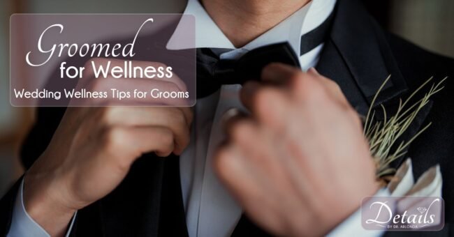 A groom straightens his tie. Wedding wellness for grooms can help relieve stress before the big day.